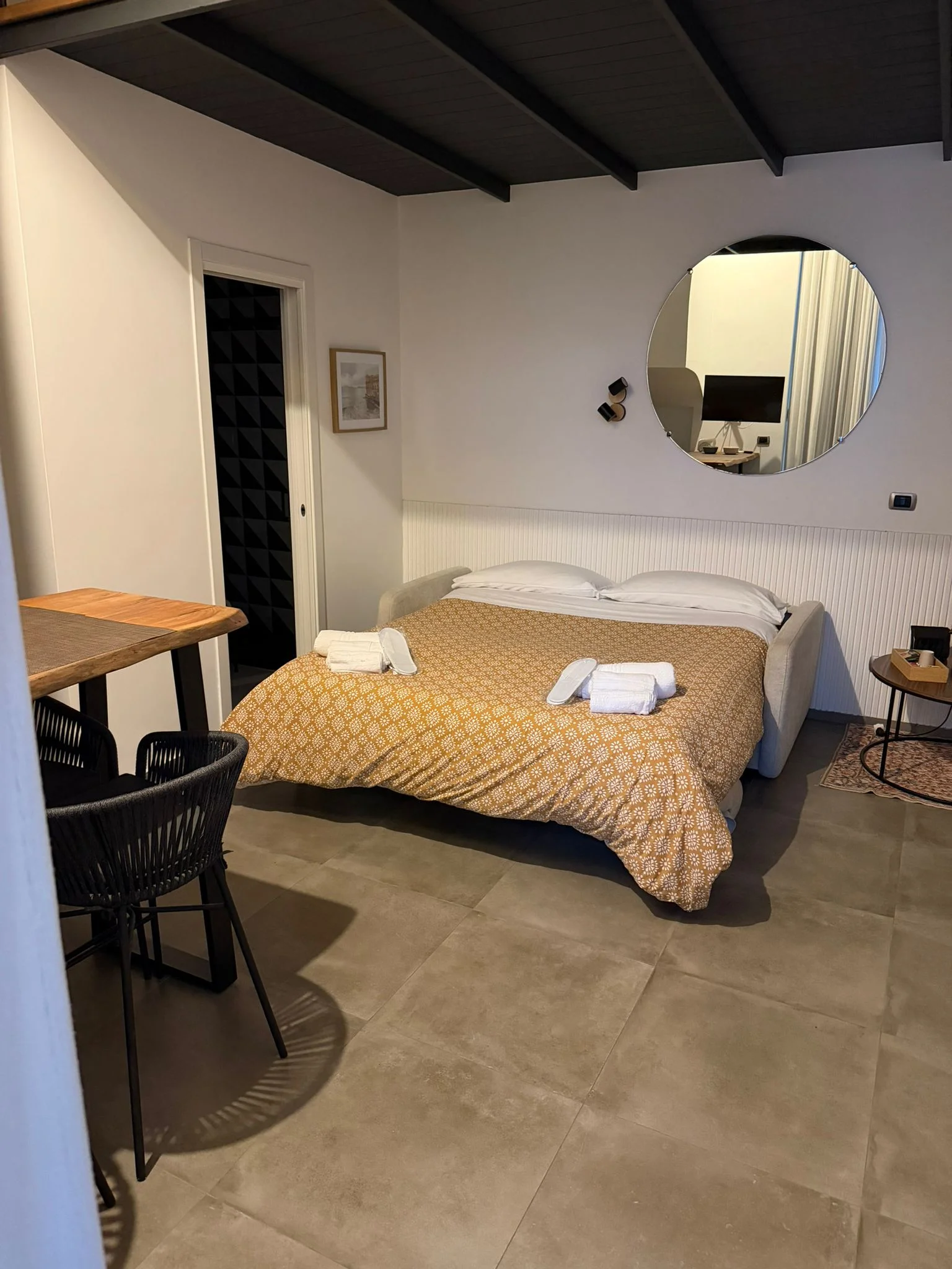 Camera Quadrupla — zona letto con specchio rotondo